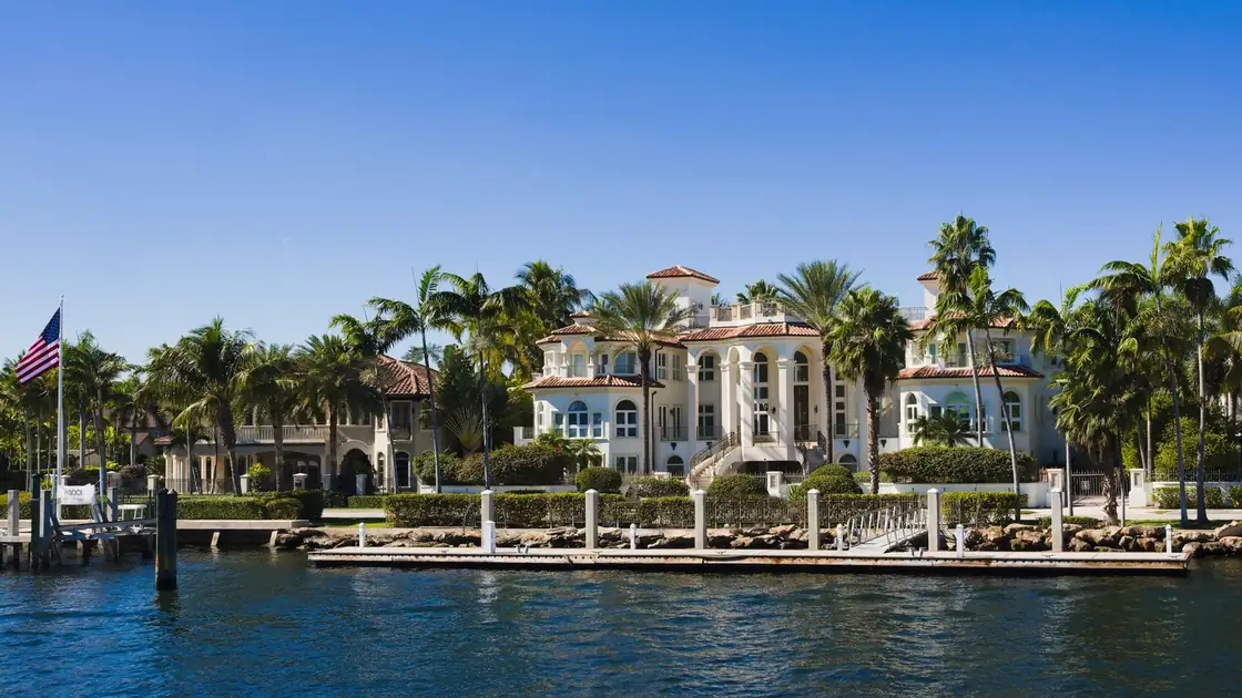 Tile-roofed waterfront homes lined with palms on a Florida canal